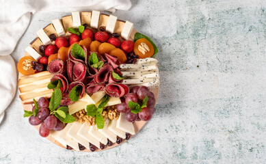 Cold Smoked Meat Plate, antipasto set platter wooden plate. Antipasto board with sliced meat, ham, salami, cheese. Top view. Empty space for text. copy space