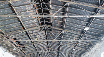 Gable roof truss of a large, vintage factory hall. Roofing construction .(sheathing) made of wooden...