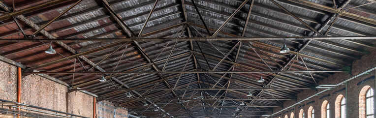 Gable roof truss of a large, vintage factory hall. Roofing construction (sheathing) made of wooden...
