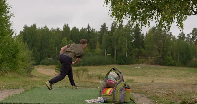 Disc golfer throws a forehand opening throw