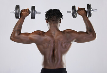 Fototapeta na wymiar Fitness, exercise and training of strong black man with dumbbell in studio. Body or back of bodybuilder person doing workout to train with weights for power, health and wellness or growth motivation