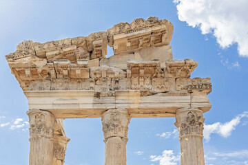 The Temple of Trajan in Pergamon Ancient City. Close up fragment of the entablature of the ruined temple with a stone-cut relief on the frieze. History, art or architecture concept. Bergama, Turkey