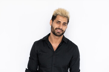 Portrait of happy young man looking at camera and smiling. Caucasian guy with stubble and highlighted hair wearing black T-shirt posing over white background. Male beauty concept