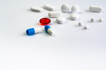 multi-colored pills of vitamins, dietary supplements on a white table close-up