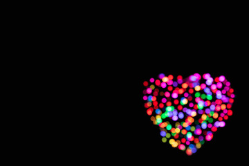 Abstract background of multicolored blurred lights in the shape of a heart with copy space