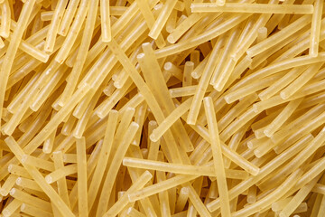 Pasta raw, vermicelli, background uniform texture, bunch in bulk close-up macro top view