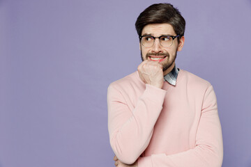 Young sad mistaken scared pensive minded caucasian IT man he wear casual clothes pink sweater glasses look aside biting nails fingers isolated on plain pastel light purple background studio portrait.