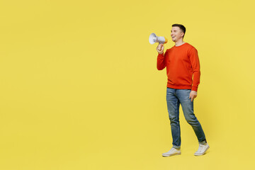 Full body young happy man wear orange casual clothes hold in hand megaphone scream announces discounts sale Hurry up isolated on plain yellow color background studio portrait People lifestyle concept