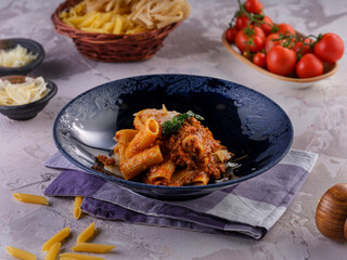 Penne pasta in tomato sauce with chicken, tomatoes garnished with parsley on a wooden background
Photo Formats