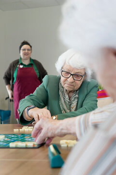 Senior inhabitants playing board game in rest home