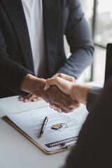 The salesperson of the housing estate in the project and the customer shake hands after...