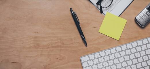 Schreibtisch mit Kugelschreiber, Tastatur, Telefon, Klebezettel