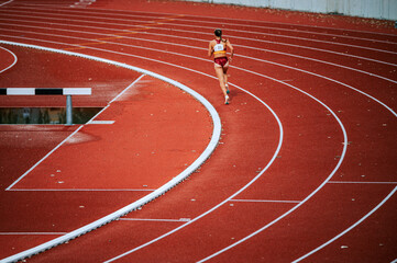Focused female athlete pushing his limits in a distance race on track. Suitable for sports and...