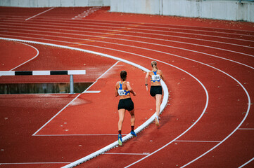 Intense female athletes at the peak of competition in long distance race. Suitable for sportswear,...