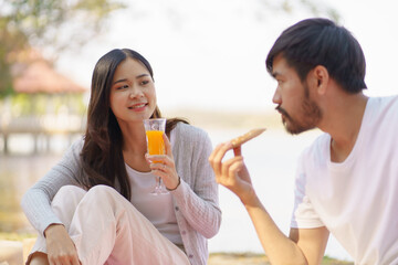  In love asian couple enjoying picnic time in park outdoors Picnic. happy couple relaxing together with picnic Basket