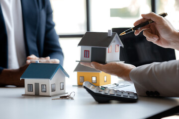 Real estate agents explain models of housing estates in projects to elaborate to clients,...