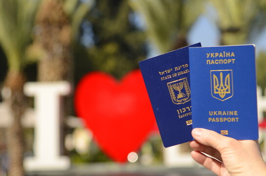 The concept of changing citizenship. Repatriation. Law of Return. Women's hands holding an Israeli passport and a Ukrainian passport