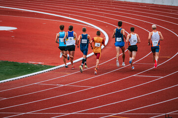 Dynamic image of long distance runners in motion during a 5000m race, showcasing determination and...
