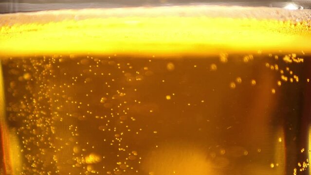 Extreme Close up of craft Beer bubbles floating to the top of a pint glass with foam