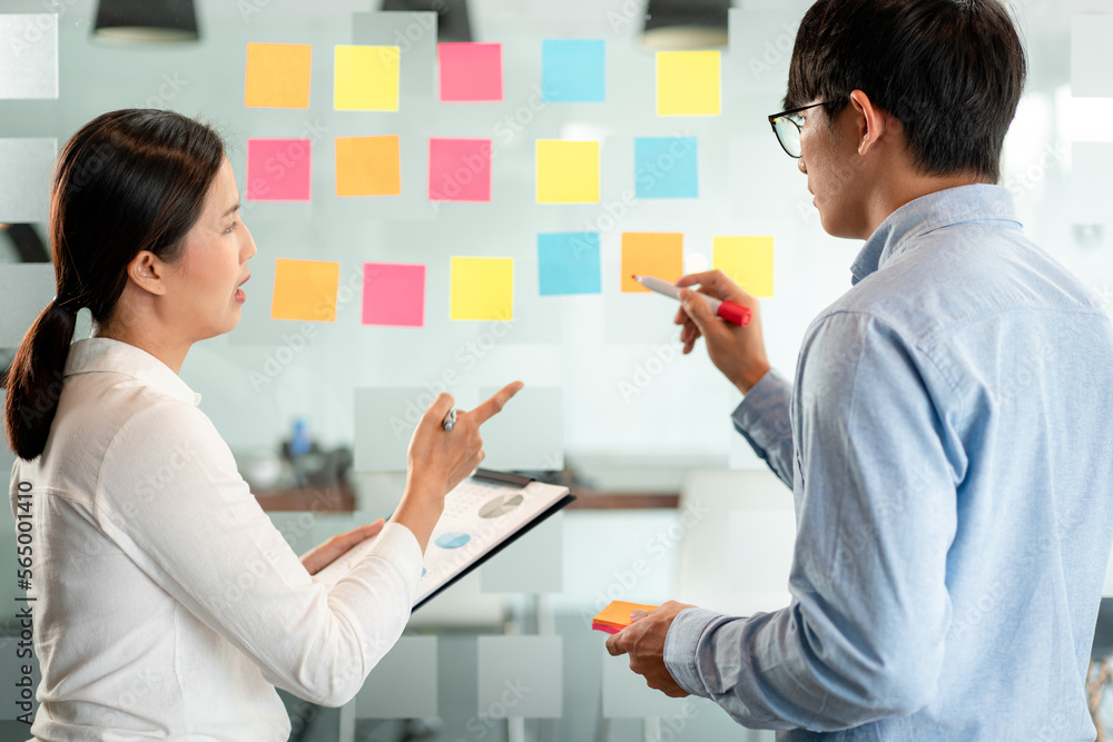 Poster two business executive team holding and taking notes keyword on board wall to brainstorm about a new