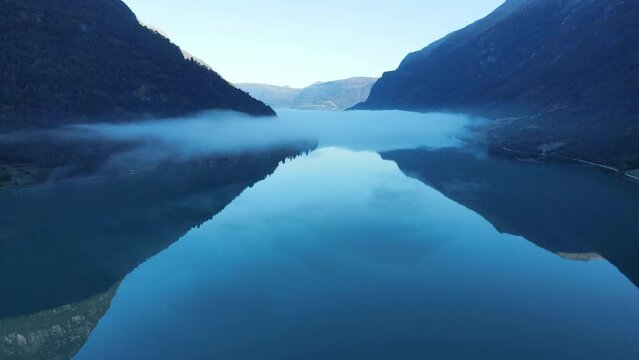Famous Oldevatnet glacier lake in Norway in early morning. Clouds over the water. Drone footage