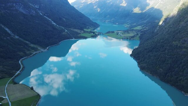 Oldevatnet glacier lake  in Norway with green water, reflection of clouds and mountains in it. Drone footage