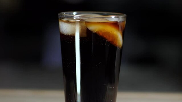 Fizzy Soda Bubbles rising in a pint glass with ice