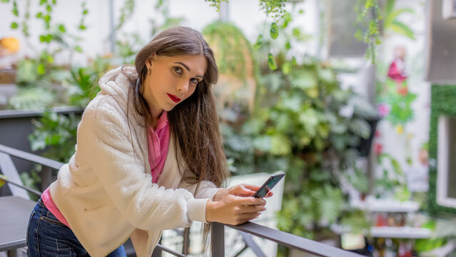 transgender woman checking smart phone content in city street