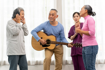 Group of senior peoples enjoy playing guitar and singing together in living room