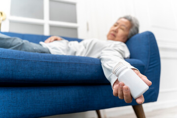 Asian senior woman lying unconscious on the sofa with overdosed