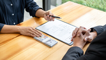 Bribe employer is handing over a pen and offer terms to businessman for signing on contract while making corruption about buy land and real estate