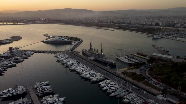 A captivating drone shot of the Floisvos Marina and Averof Battleship during a beautiful sunset