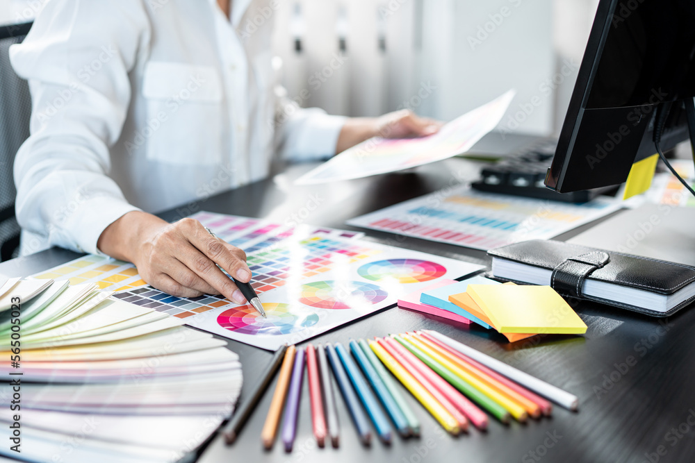 Poster Young creative graphic designer working on color selection and drawing on graphics tablet at workplace, Color swatch samples chart for selection coloring in inspiration to create new collection
