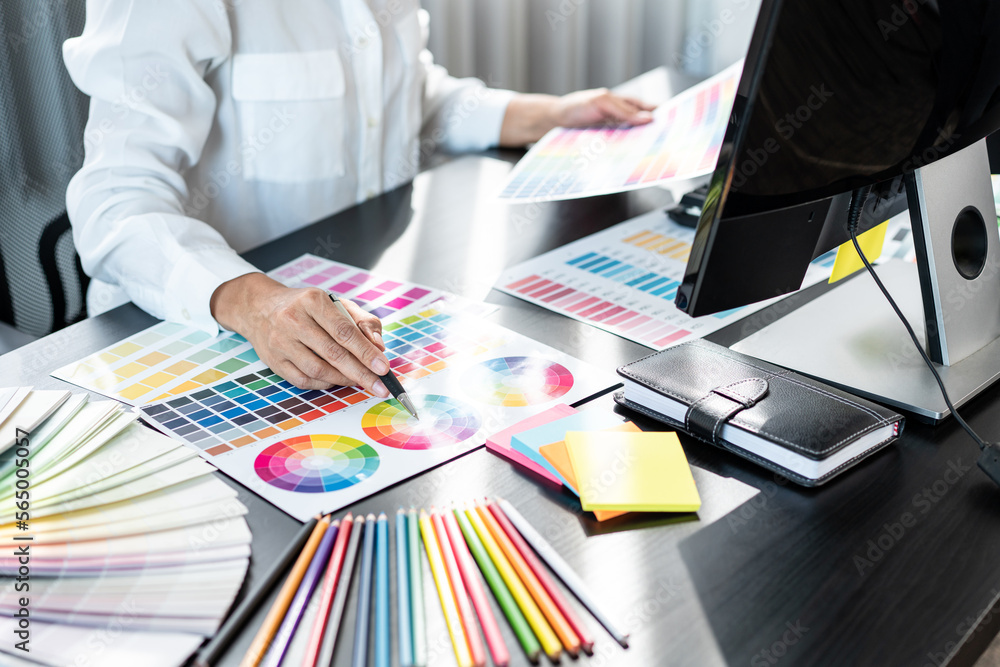 Poster Young creative graphic designer working on color selection and drawing on graphics tablet at workplace, Color swatch samples chart for selection coloring in inspiration to create new collection