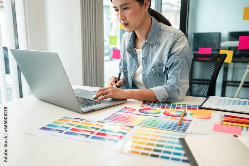Aufkleber Young creative graphic designer working on color selection and drawing on graphics tablet at workplace, Color swatch samples chart for selection coloring in inspiration to create new collection