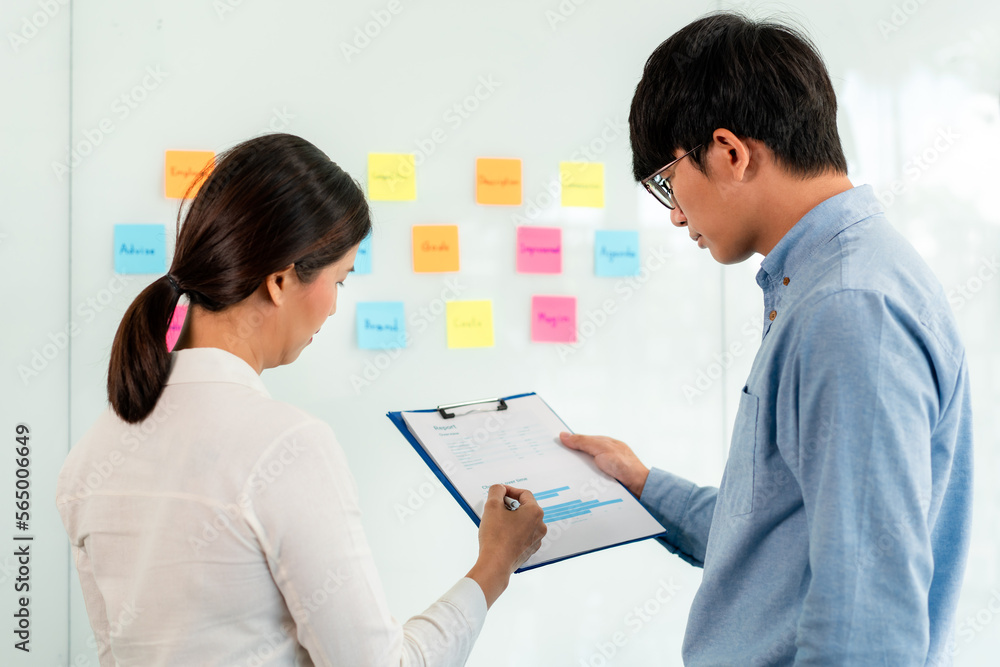 Poster two business executive team holding and taking notes keyword on board wall to brainstorm about a new