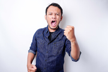 Fototapeta premium The angry and mad face of Asian man in blue shirt isolated white background.