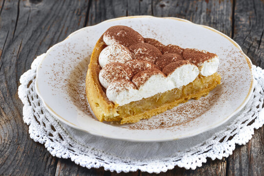 Apple pie with cream on wooden background