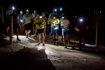 Ultra marathon runners prepare to begin the race in darkness.