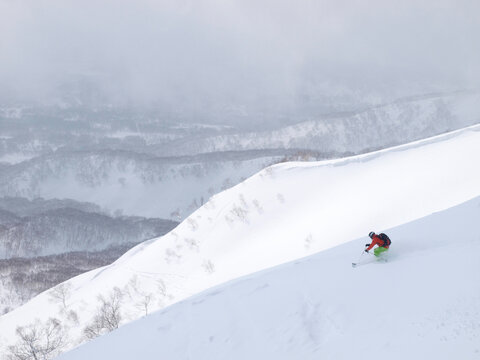 A skier is descending the Annapuri mountain in Niseko, Japan.