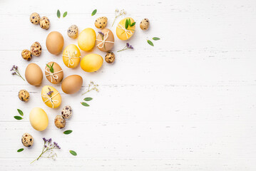 Festive Easter background. Easter eggs with flowers on a white table. Flat lay, place for text.