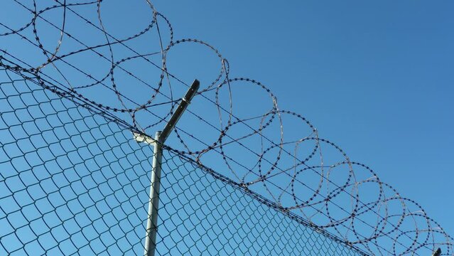 Prison barbed wire fence against the blue sky the concept of prohibition of entry and protection of private property. Scoreboard, restricted area, prohibited access
