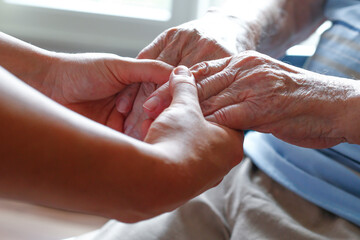 Hände älterer Menschen in der Pflege im Altenheim