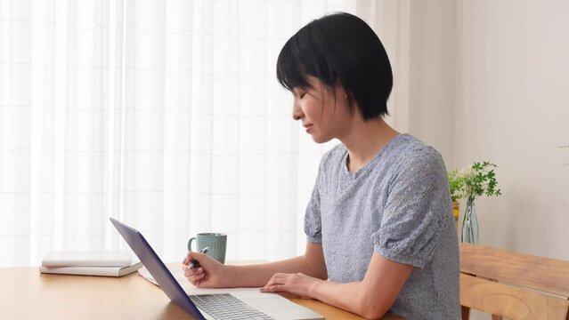eラーニング　自宅でパソコンを使って勉強する女性