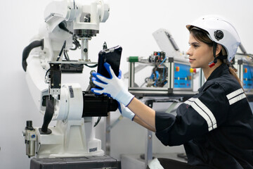 Computer science development engineer working on robotic arm connection and control using tablet software. Woman in industry 4.0 robotic engineering workshop in electronic futuristic technology center