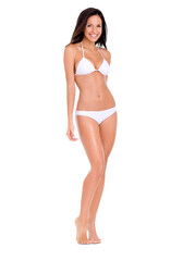Obraz premium A full length shot of a beautiful young woman wearing a white bikini standing looking at the camera isolated on a PNG background.