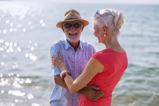 Couple Of Old Mature People Dancing Together On The Sand At The Beach Enjoying And Living The Moment