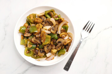 Fresh stir fried or sauteed vegetables. broccoli, zucchini, green and red peppers, mushrooms, onions, baby corn. colorful veggies in a white plate. Weightloss journey. Fitness concept. Healthy life.