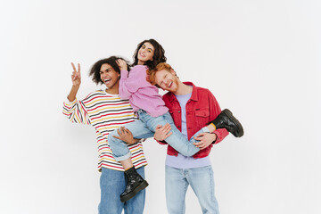 Fototapeta premium Two young handsome smiling men holding young beautiful smiling woman