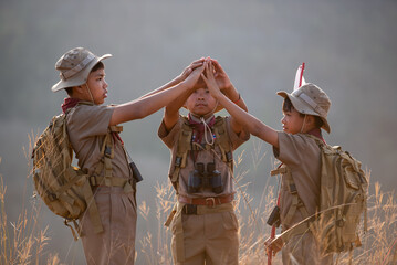 Scouts hold hands in camp, a strong idea about teamwork and cooperation, which also means immigration and friendship. - obrazy, fototapety, plakaty